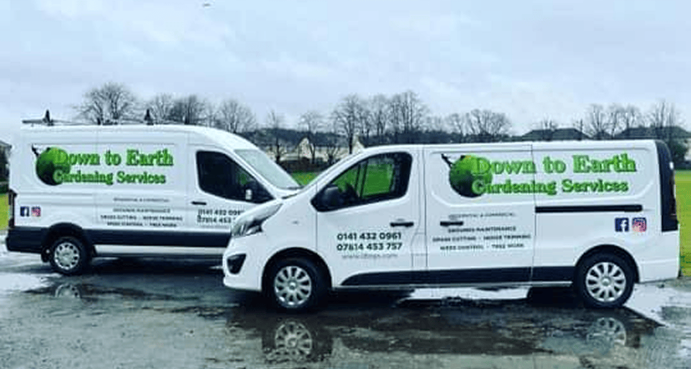 image of two vans facing each other in the rain and concrete with the Down to Earth Garden Services logos and advertising in green on the vans.