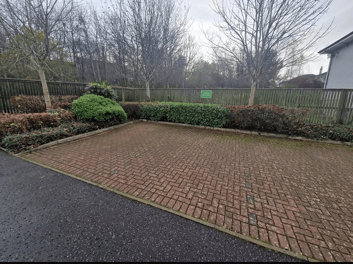  A beautiful stately home front garden with superbly mowed grass and pebble stones around the large front parking area with a 4 by 4 vehicle parked at the corner 