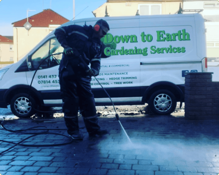 This is an image of the down to earth garden services team pressure washing a driveway cleaning all the hard to get debris